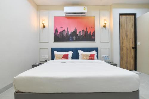 a bedroom with a large white bed with red pillows at Aceotel Select Virat, Vijay Nagar in Indore