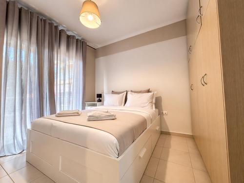 a white bedroom with a large bed and a window at MK Seaview Stays in Neos Marmaras