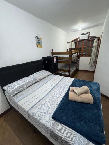 a bedroom with a bed with a towel on it at Suítes como uma onda in Abraão