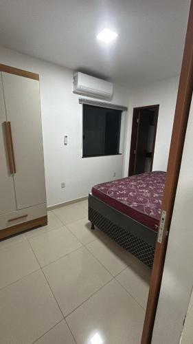 a bedroom with a bed and a window in it at Temporadaemjaua in Camaçari