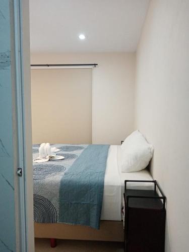a bedroom with a bed with a blue and white blanket at Hermoso apartamento nuevo in Isla Mujeres