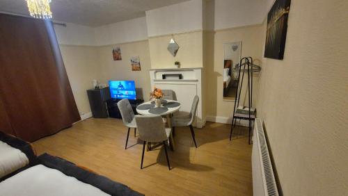 a living room with a table and chairs and a bedroom at The ultimate group stay in Catford
