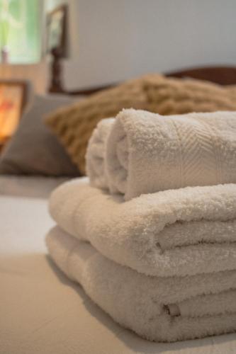 a pile of towels sitting on top of a bed at Aloha Nelly - Departamento de alquiler por día in Trelew