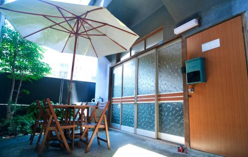a patio with a table and an umbrella at BLUE HOUSE - Traditional Home - 5min, Beach, Bus, Train in Beppu
