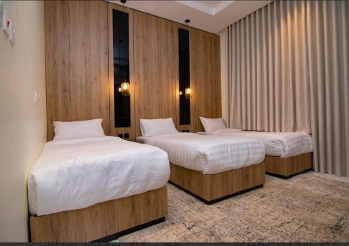 two beds in a room with wooden walls at Princess House in Jeddah