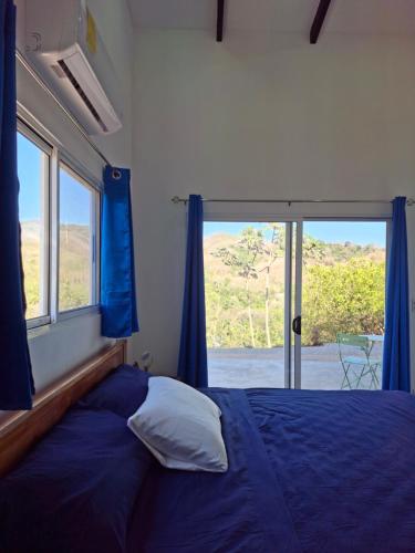 a bedroom with a bed and a large window at Pura Vista Lodge in Sámara