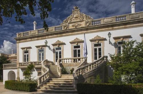 a large white building with stairs in front of it at Coimbra Heights in Coimbra