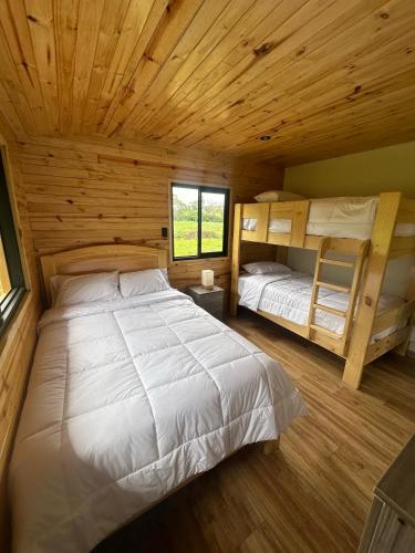a bedroom with two bunk beds in a log cabin at Villa Alpina in Oxapampa