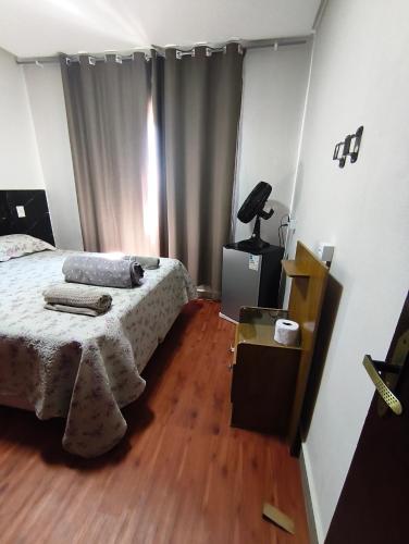 a bedroom with a bed and a wooden floor at APART HOTEL Lar Doce Lar 2 & 7 in Arcos