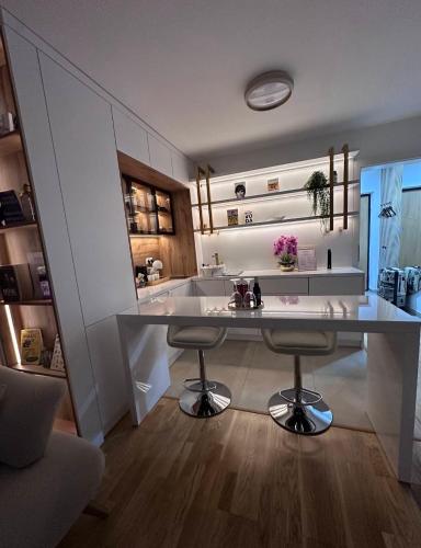 a kitchen with a large counter and two bar stools at SOL LUX Tuzla in Tuzla