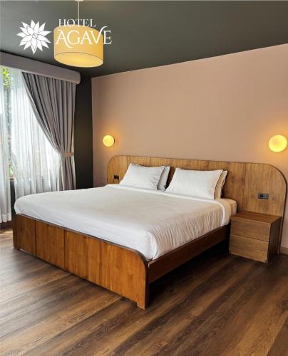 a bedroom with a large bed with white sheets at Hotel Casa Agave in Baños