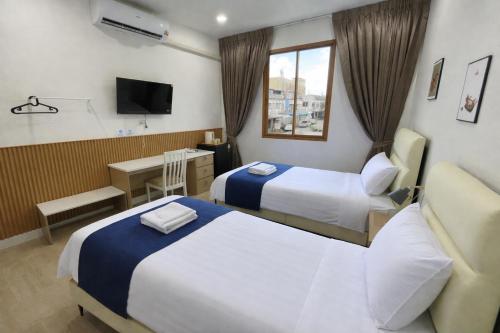 a hotel room with two beds and a television at MinimalYala in Yala