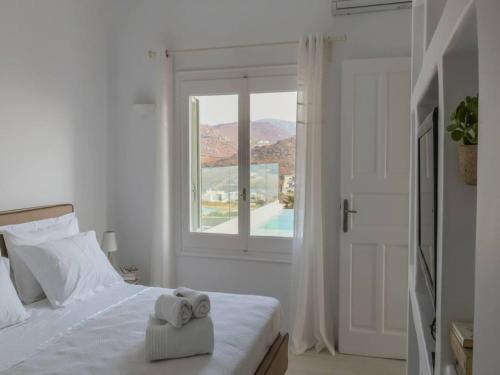 a bedroom with a bed with two towels on it at Kalafatis Stay with Private Pool in Kalafatis