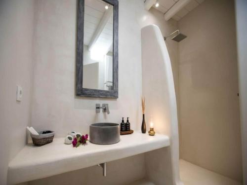 a bathroom with a sink and a mirror on a counter at Suite with Jacuzzi & Sea View in Mikonos