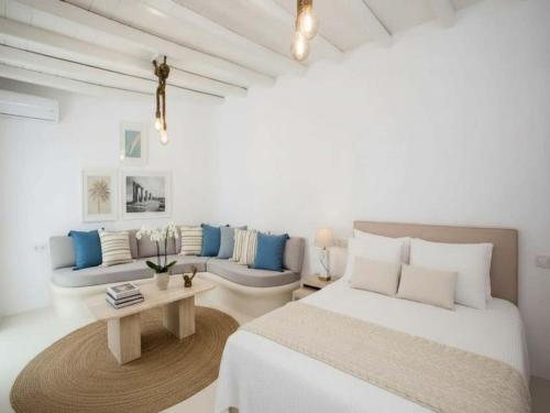 a white room with a bed and a couch at Suite with Jacuzzi & Sea View in Mikonos