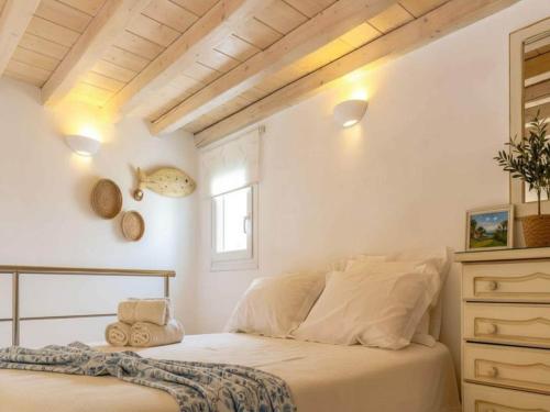 a white bedroom with a bed and a window at Ano Mera Villa with Private Pool in Ano Mera