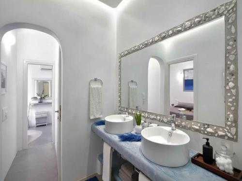 a bathroom with two sinks and a large mirror at Panormos Retreat with Pool in Mikonos