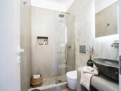 a bathroom with a sink and a glass shower at Panormos Stay for Seven Guests in Mikonos