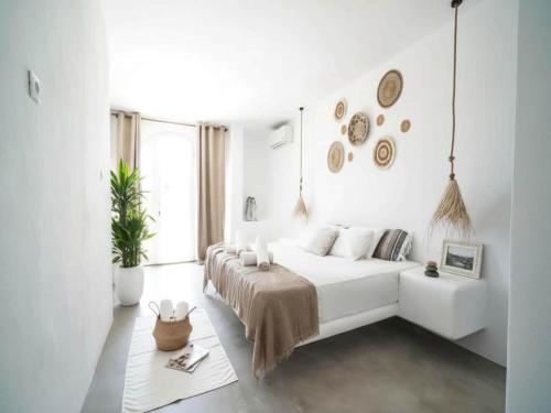 a white bedroom with a bed and a couch at Panormos Stay for Seven Guests in Mikonos