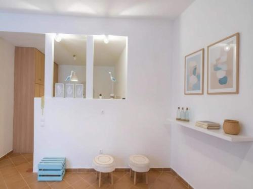 a bathroom with two stools and a mirror at 3-Bed Home in Ano Mera in Ano Mera
