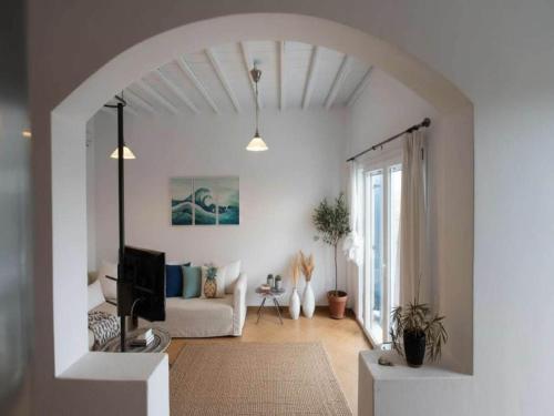 a white living room with a couch and a tv at 3-Bed Home in Ano Mera in Ano Mera