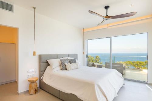 a bedroom with a bed and a large window at Kokkari Villa in Kokkari