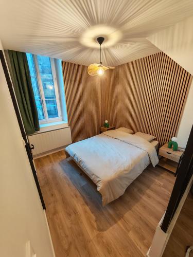 a bedroom with a bed and a ceiling at L'immeuble du Monde Rose - Appartements neufs climatisés - classés 3 étoiles - Vic le Comte - Auvergne in Vic-le-Comte