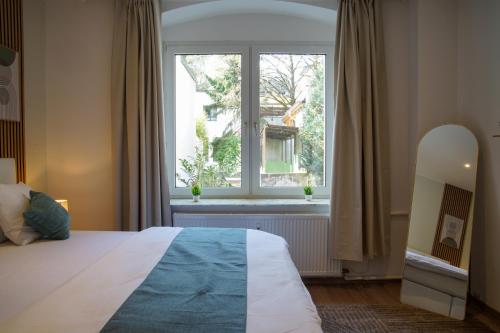 a bedroom with a bed and a large window at Bielefeld Grand Central Residence in Bielefeld