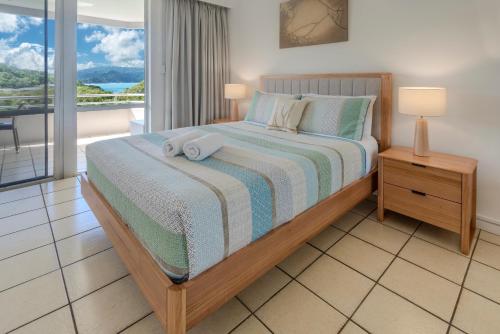 a bedroom with a bed with two towels on it at Poinciana 106 in Hamilton Island