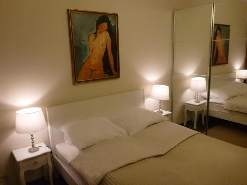 キェルツェにあるApartament na Solnej z widokiemのベッドルーム1室(ベッド1台付)が備わります。壁には絵画が飾られています。