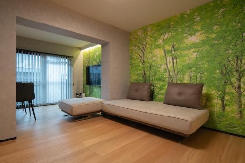 a living room with a couch and a green wall at PaPa's Resort 那須 in Nasushiobara