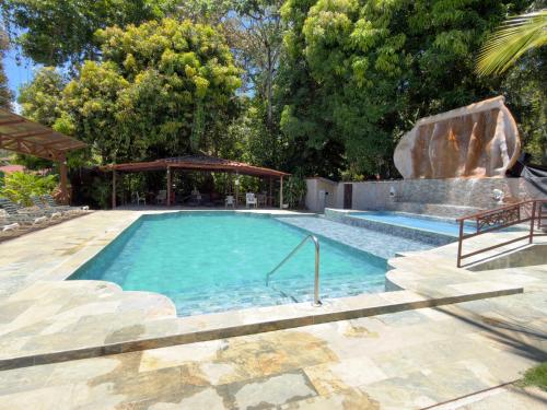 a large swimming pool with a rock in the middle at Hotel Manuel Antonio Park in Manuel Antonio