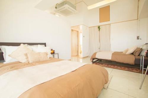 a large bedroom with two beds and a couch at GUEST HOUSE SORA 2 in Okinawa City