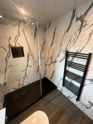 a bathroom with a marble wall with a shower at Cameron apartment Loch Ness in Fort Augustus