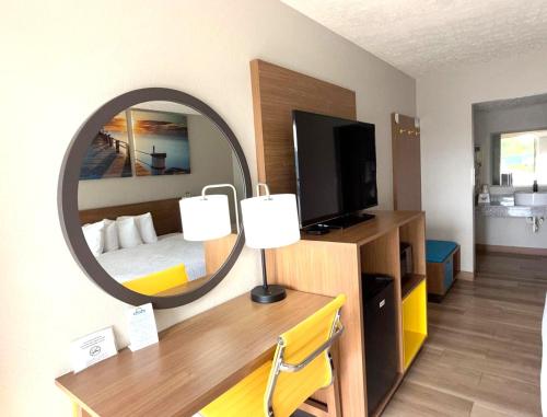 a hotel room with a bed and a mirror at Days Inn by Wyndham Frankfort in Frankfort