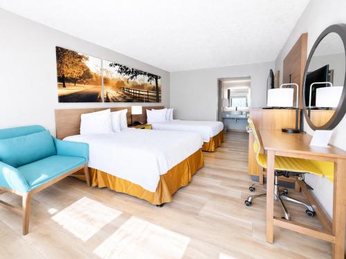 a hotel room with two beds and a desk at Days Inn by Wyndham Frankfort in Frankfort