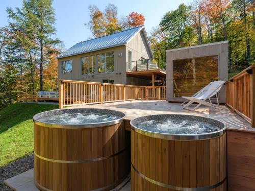 a house with two hot tubs on a deck at Private Nordic Spa Retreat - Mont-Tremblant in Lac-Superieur