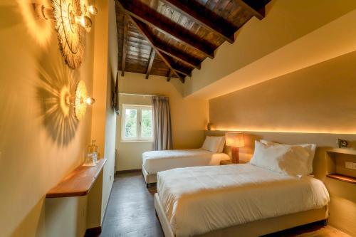 a hotel room with two beds and a window at Solar Alvura Boutique Hotel in Moncarapacho