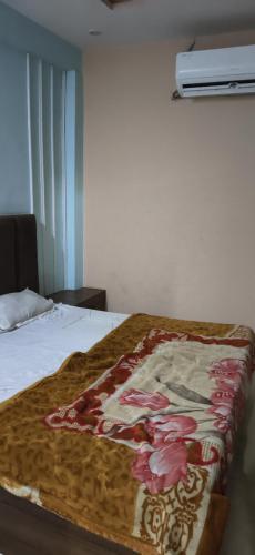 a bed with a blanket on top of it at Madhav guest house in Agra