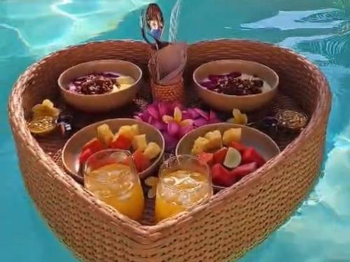 a heart shaped basket with fruit and drinks in a swimming pool at ZENARA lombok - Boutique Adults Only in Kuta Lombok