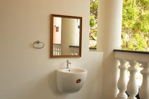 a bathroom with a sink and a mirror on the wall at JPR Heritage Villa in Pondicherry
