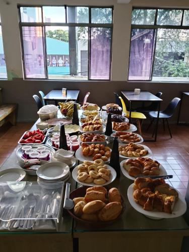 a table with many different types of food on it at Hotel Divinopolis Center in Divinópolis