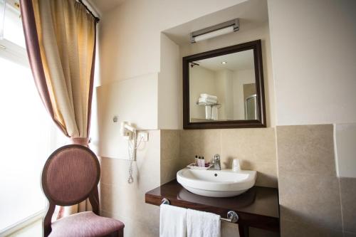 bagno con lavandino e specchio di Hotel dei Coloniali a Siracusa