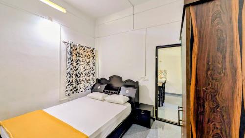 a white bedroom with a bed and a mirror at Winter Bloom Homestay Munnar in Munnar