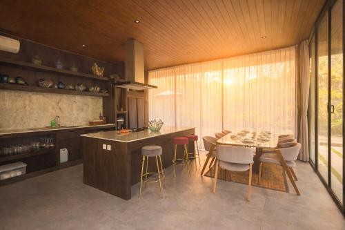 a kitchen with a table and chairs and a dining room at The Garden Villas in Ubud