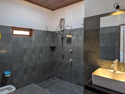 a bathroom with a shower and a sink at Randiwa Homestay in Sigiriya