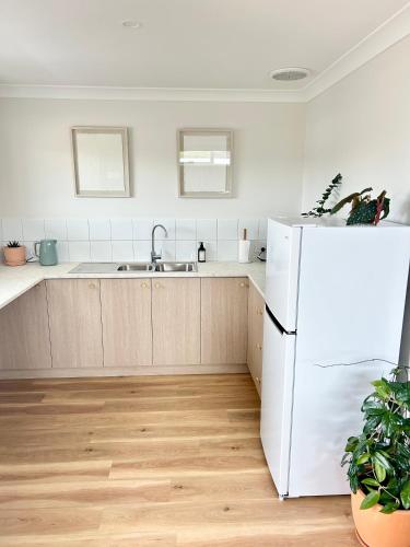 a kitchen with a white refrigerator and a sink at La Porta Rosa in Bunbury