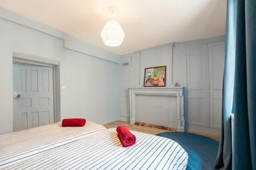 a bedroom with a bed with red pillows on it at Le Bleu et Rubis in Falaise