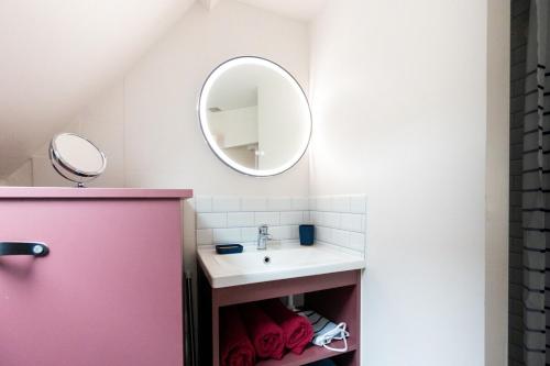 a bathroom with a sink and a mirror at Le Bleu et Rubis in Falaise