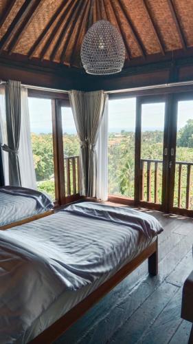 a bedroom with a bed and a large window at Villa WENHOMANN View in Lovina